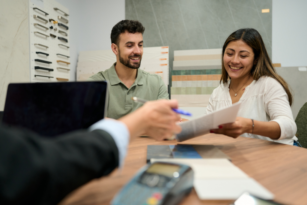 Couple reviewing renovation material samples and signing loan paperwork with their lender 